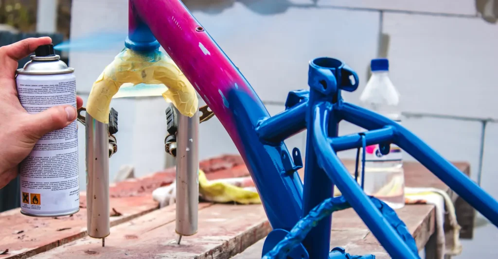 man-paints-bicycle-with-spray-paint